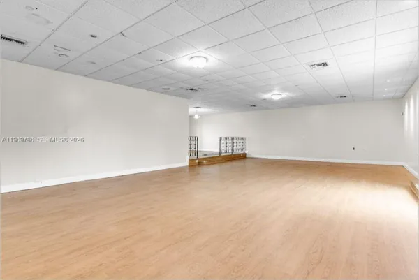 an empty room with a ceiling fan and windows