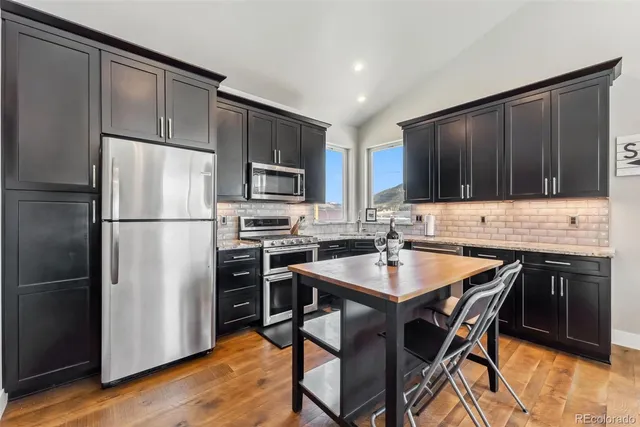 a kitchen with a refrigerator a stove top oven a sink and cabinets