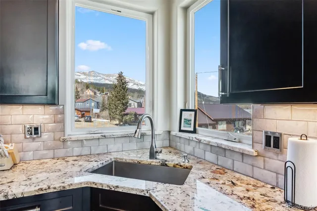 a kitchen with granite countertop sink and cabinets