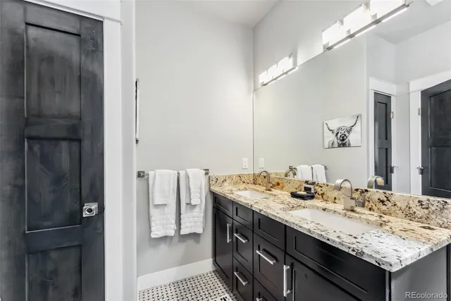 a bathroom with a granite countertop sink and a mirror