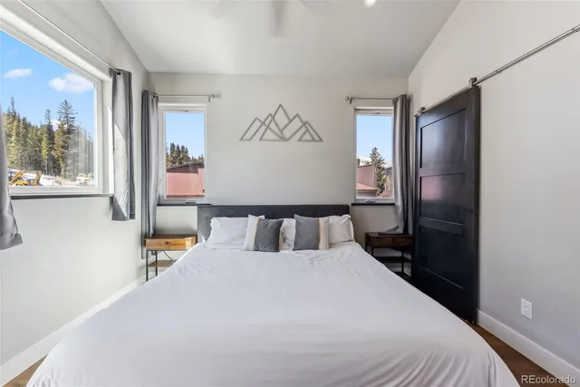 a bedroom with a bed and painting on the wall