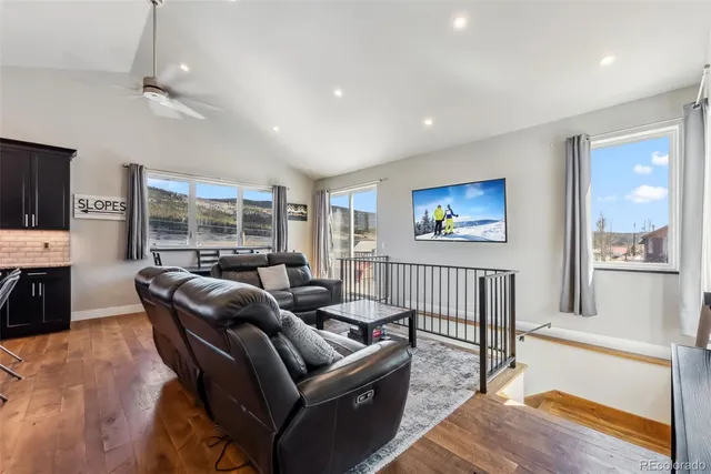 a living room with furniture a flat screen tv and a large window