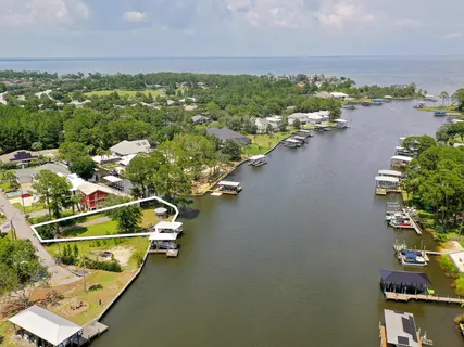 an aerial view of residential houses with outdoor space and river