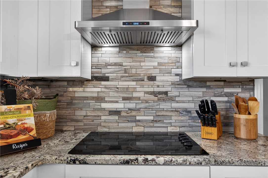 103 Granby Place Portland, TX 78374 - Photo 15 of 40 a kitchen with granite countertop a stove a sink and white cabinets