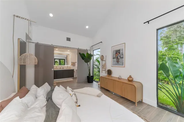 a bedroom with furniture and a large window