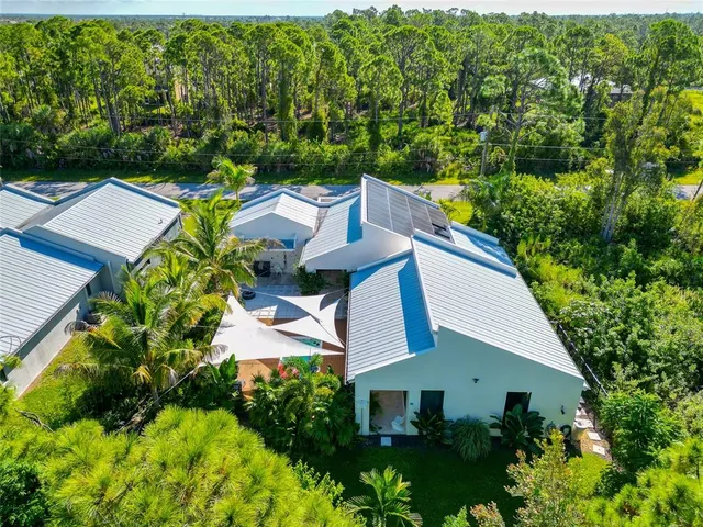 an aerial view of a house with a yard and outdoor seating