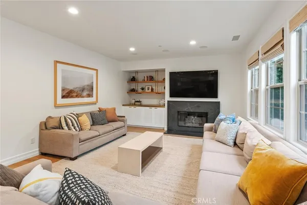 a living room with furniture a fireplace and a flat screen tv