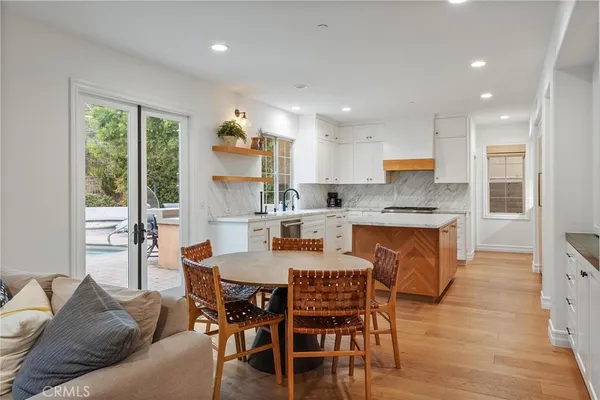 a view of a dining room with furniture and a kitchen space