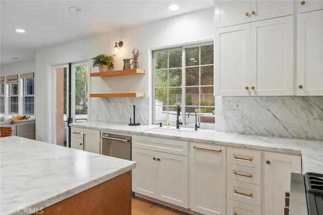a kitchen with cabinets appliances a sink and a window