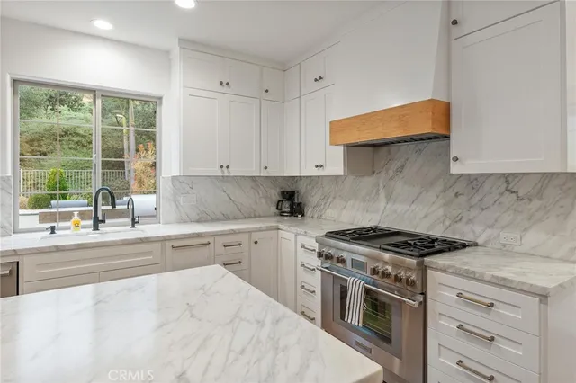 a kitchen with stainless steel appliances granite countertop a stove a sink and a microwave
