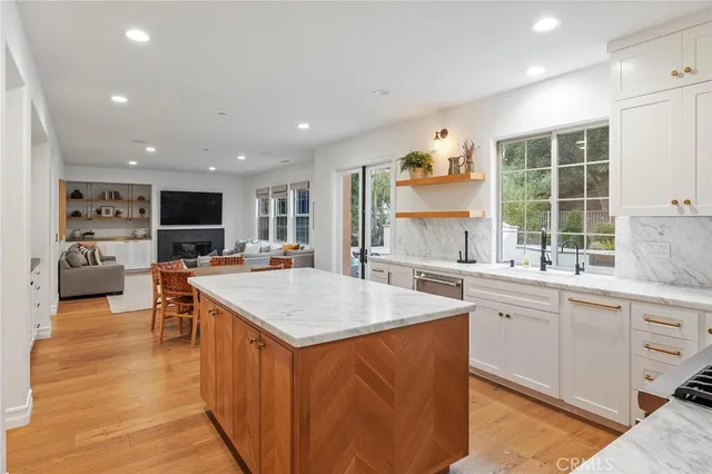 a open kitchen with stainless steel appliances granite countertop a table and chairs in it