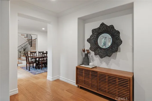 a view of a hallway with wooden floor and a dining table