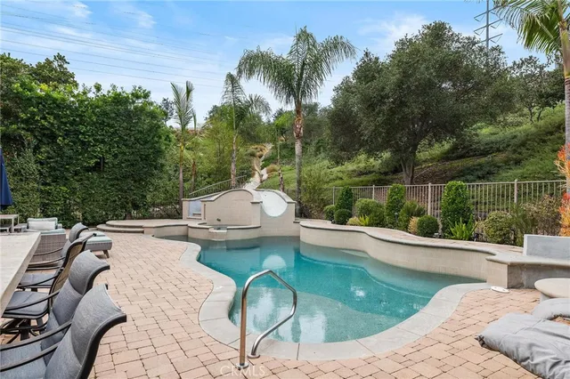 a view of a swimming pool with a garden and trees