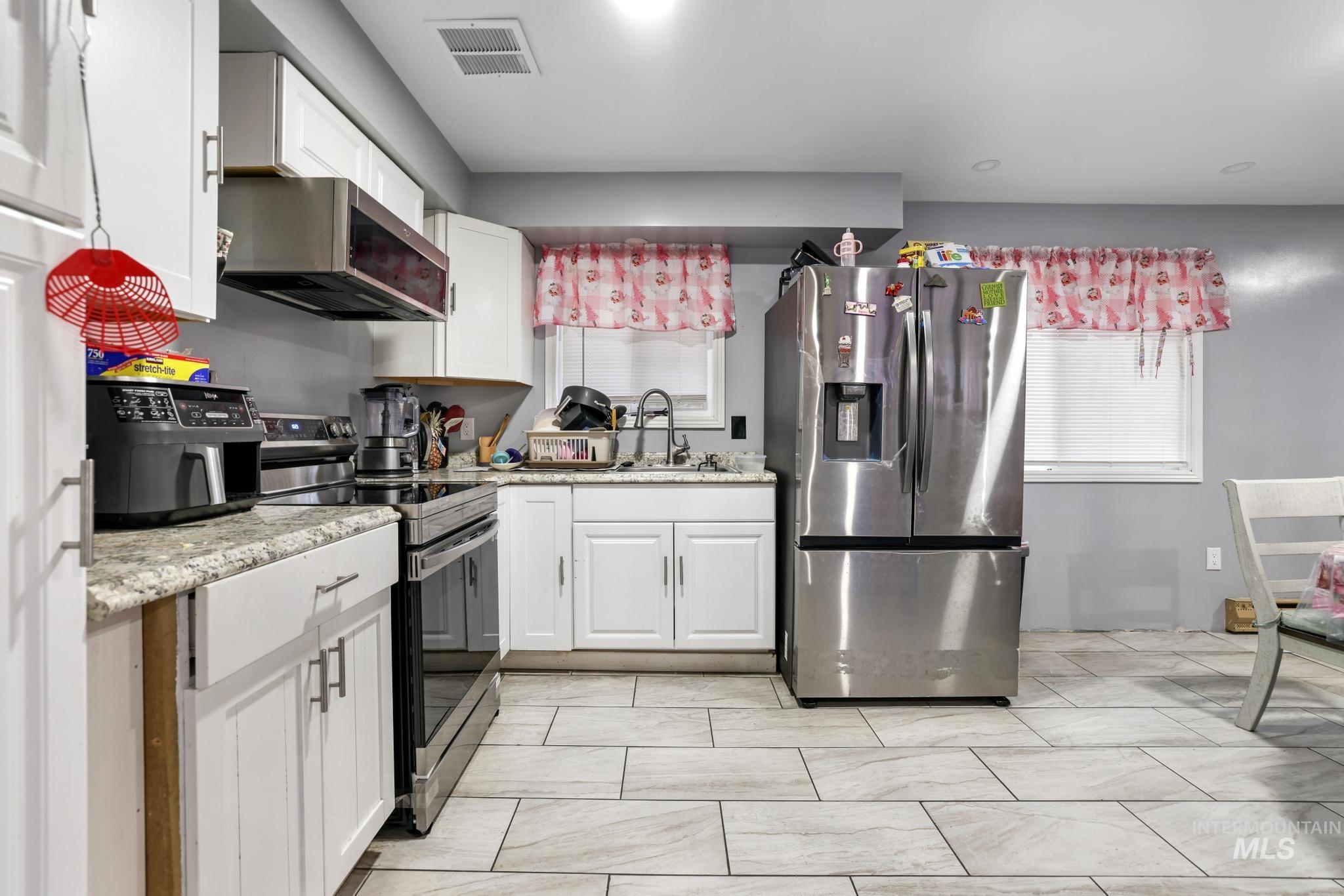 403 3rd Avenue West Jerome, ID 83338 - Photo 16 of 36 Kitchen featuring appliances with stainless steel finishes and white cabinetry
