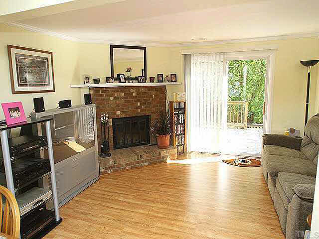 7707 Kingsberry Court Raleigh, NC 27615 - Photo 2 of 9 Roomy family room with cozy fireplace and pristine laminate wood floors. Glass doors to deck. Other