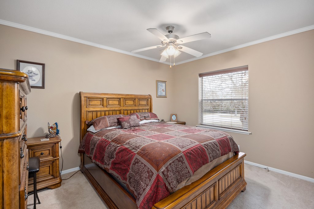 3955 Klein Branch Road Harper, TX 78631 - Photo 20 of 40 a bedroom with a bed and a chandelier