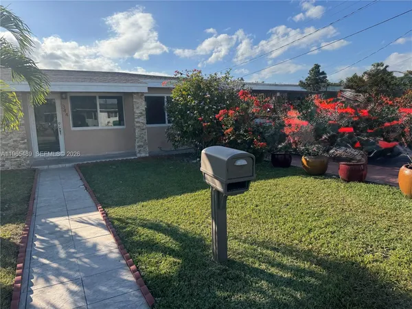 a front view of a house with a yard and fountain