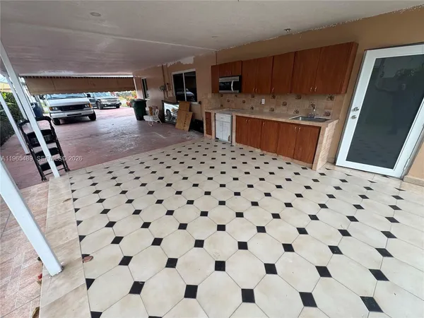 a kitchen with granite countertop a sink and a refrigerator