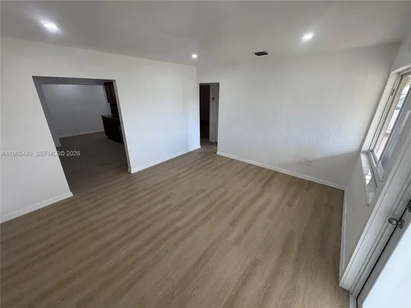 a view of empty room with wooden floor