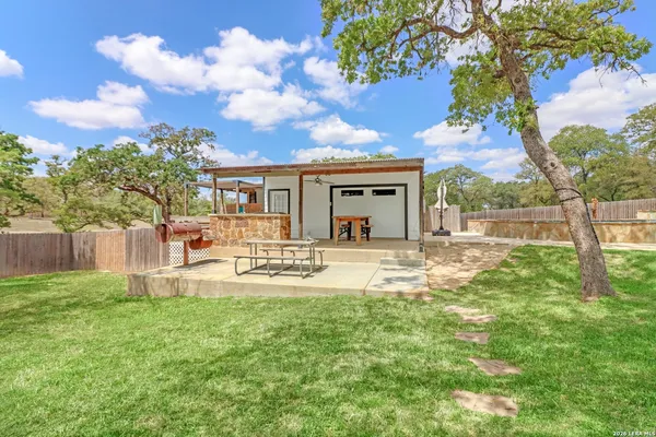 a view of house with backyard and sitting area