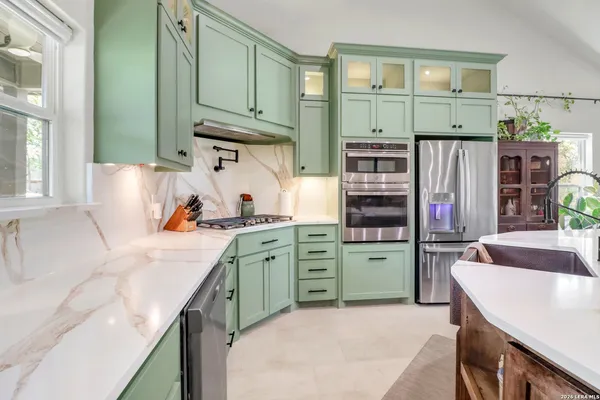 a kitchen with kitchen island a sink stove and refrigerator