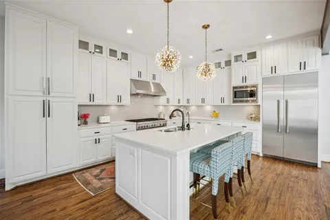 a view of living room kitchen with stainless steel appliances granite countertop couches a flat screen tv
