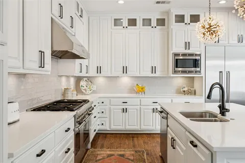 a kitchen that has a lot of cabinets and wooden floor