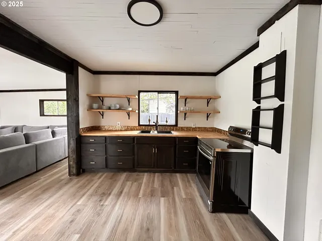 a large kitchen with stainless steel appliances granite countertop a stove and a sink