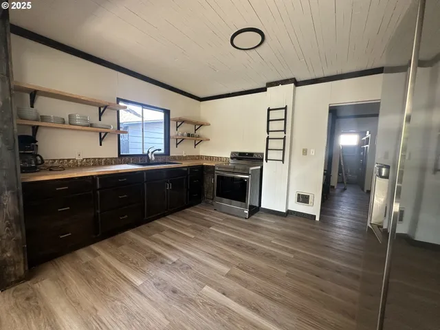 a large kitchen with stainless steel appliances granite countertop a sink and cabinets