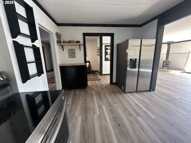 a view of a hallway with wooden floor and staircase