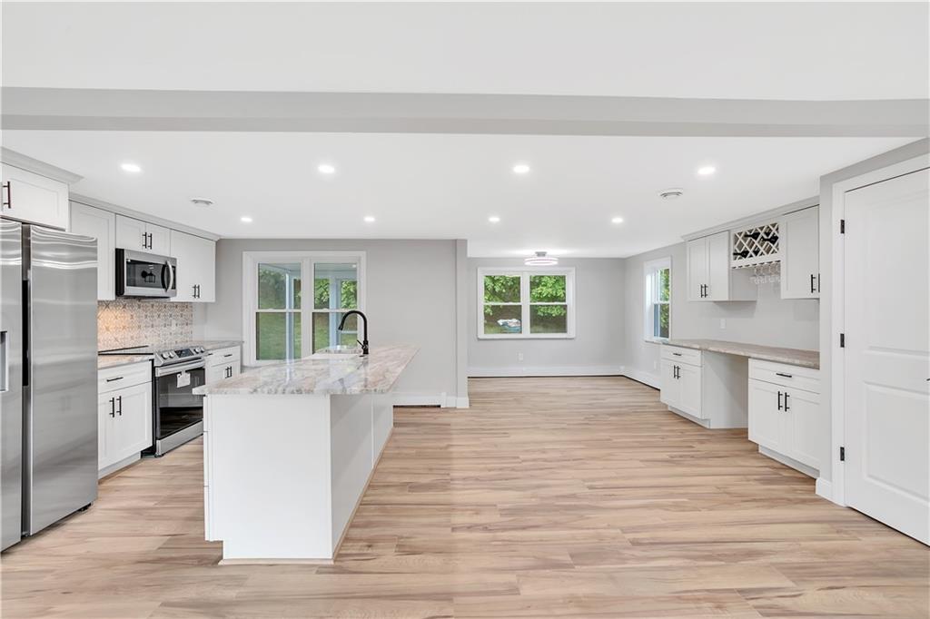 2 Hillcrest Drive Cecil, PA 15321 - Photo 12 of 25 a large white kitchen with a stove a sink dishwasher a refrigerator and white cabinets with wooden floor