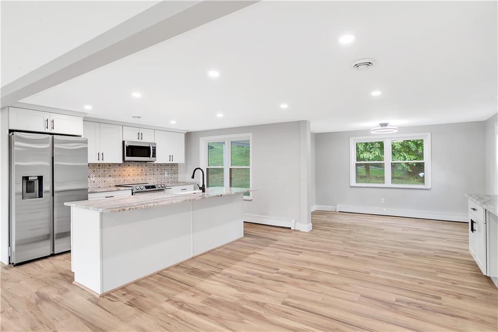 2 Hillcrest Drive Cecil, PA 15321 - Photo 9 of 25 a large kitchen with stainless steel appliances granite countertop a stove a sink dishwasher a refrigerator and white cabinets with wooden floor