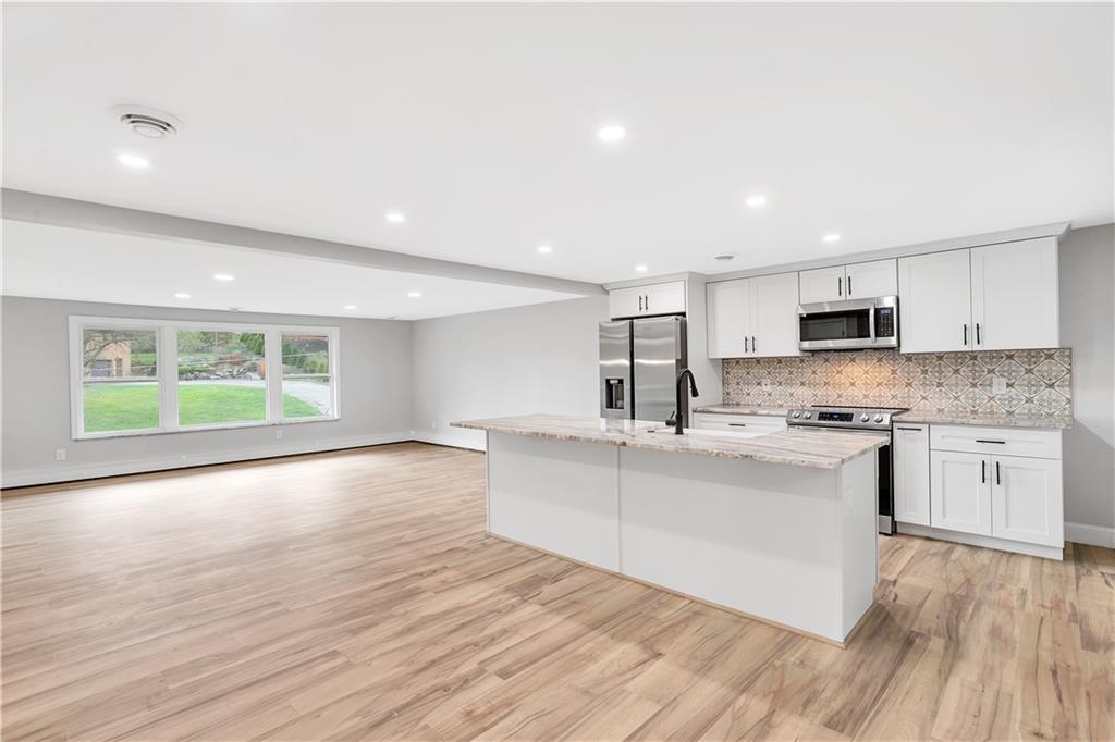 2 Hillcrest Drive Cecil, PA 15321 - Photo 10 of 25 a large white kitchen with wooden floors and stainless steel appliances