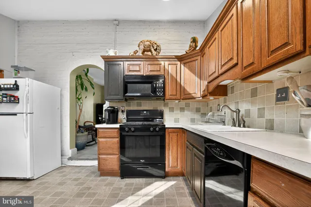 a kitchen with stainless steel appliances granite countertop a sink a stove and a refrigerator