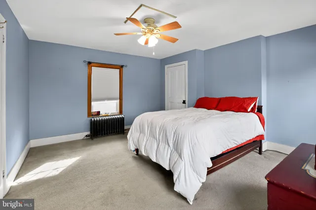 a spacious bedroom with a bed and a chandelier