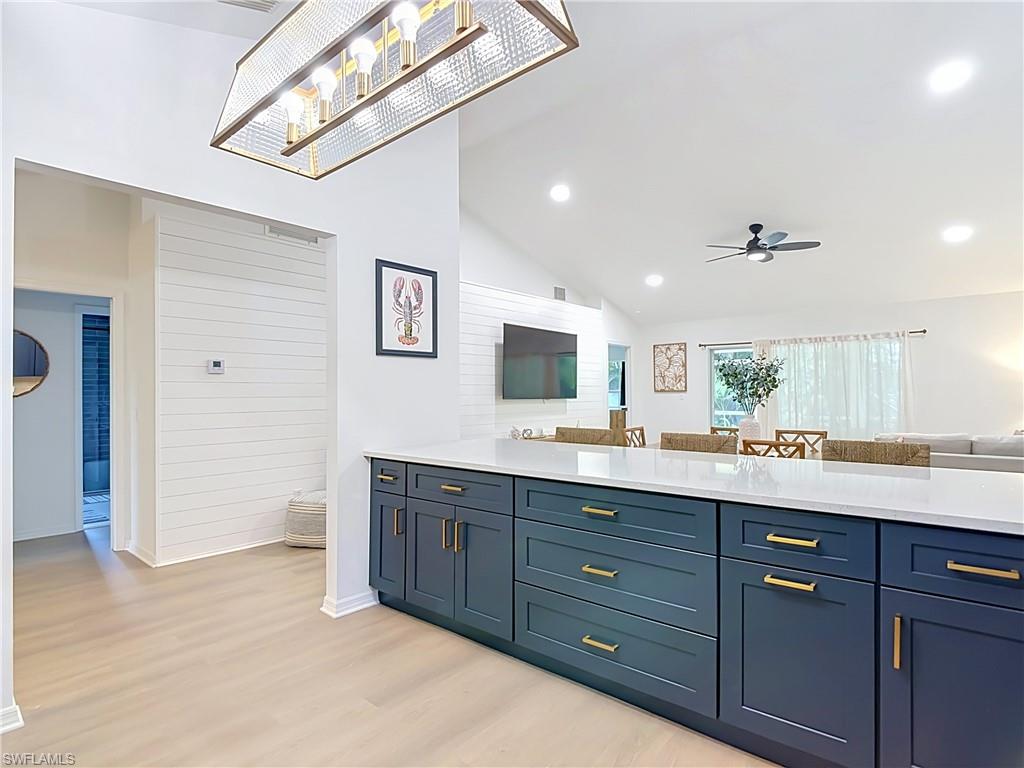 812 102nd Avenue North Naples, FL 34108 - Photo 9 of 33 Spacious open-concept interior featuring light wood-finish flooring, vaulted ceilings with recessed lighting, and a contemporary ceiling fan