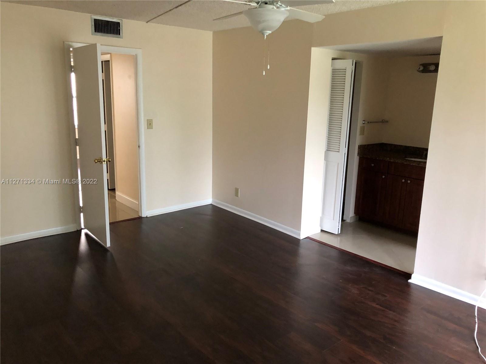 8050 West McNab Road, Unit 216 Tamarac, FL 33321 - Photo 15 of 16 an empty room with wooden floor and closet