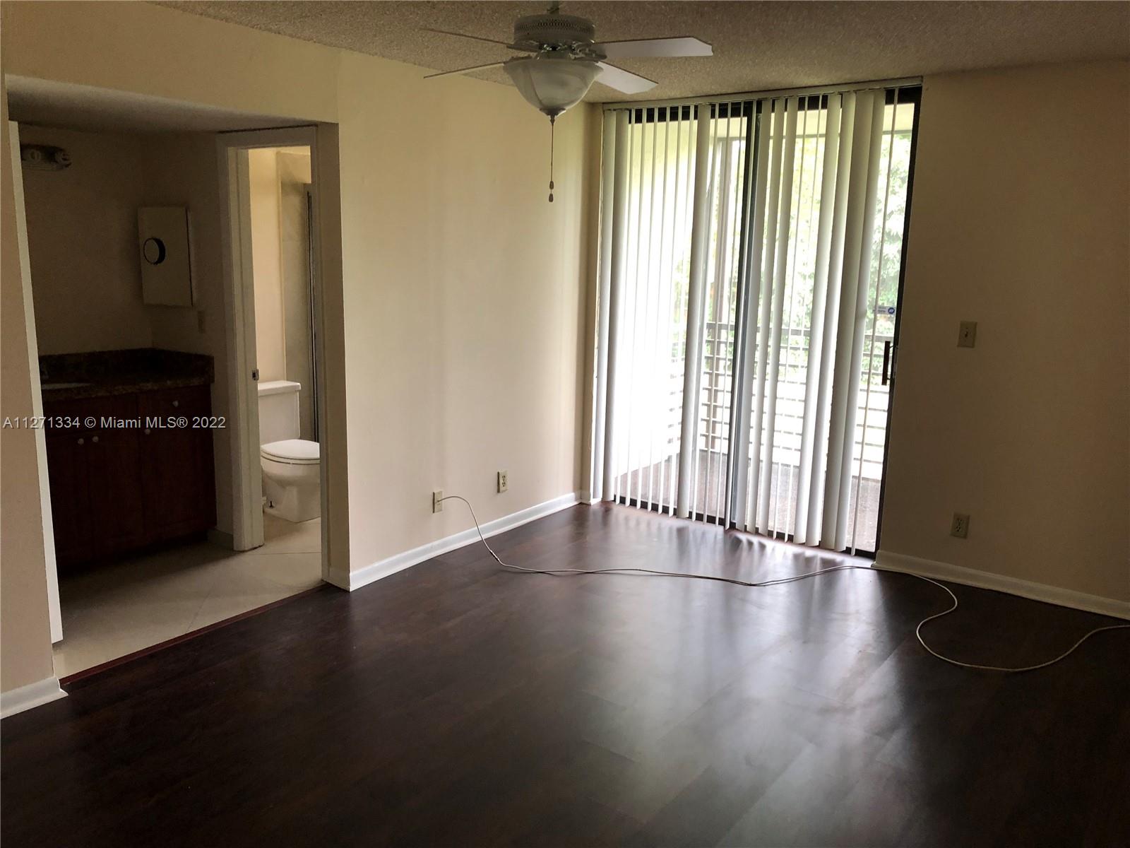 8050 West McNab Road, Unit 216 Tamarac, FL 33321 - Photo 16 of 16 an empty room with wooden floor and windows