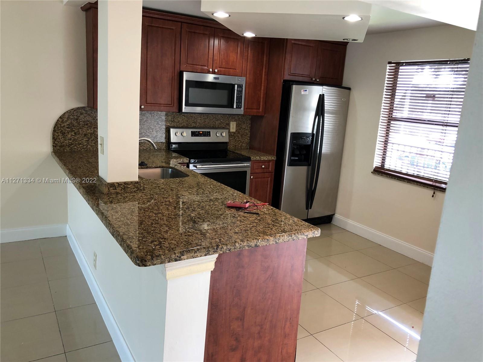 8050 West McNab Road, Unit 216 Tamarac, FL 33321 - Photo 10 of 16 a kitchen with stainless steel appliances granite countertop a microwave a refrigerator and a sink
