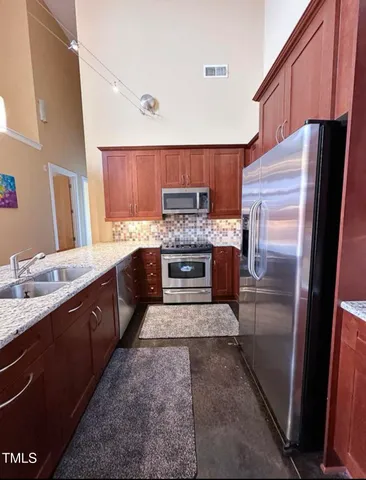 a large kitchen with a stove and a refrigerator