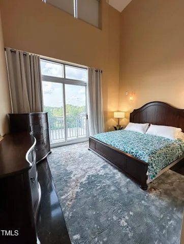 a bedroom with a large bed and a flat tv screen on dresser