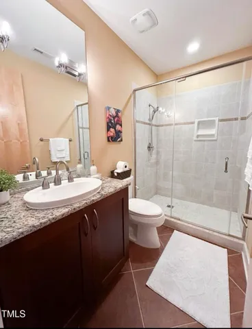a bathroom with a granite countertop sink toilet a mirror a vanity and shower