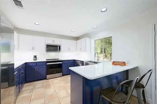 a large kitchen with stainless steel appliances granite countertop a sink and a stove
