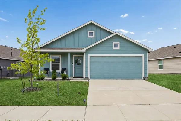 a front view of a house with a garden and plants