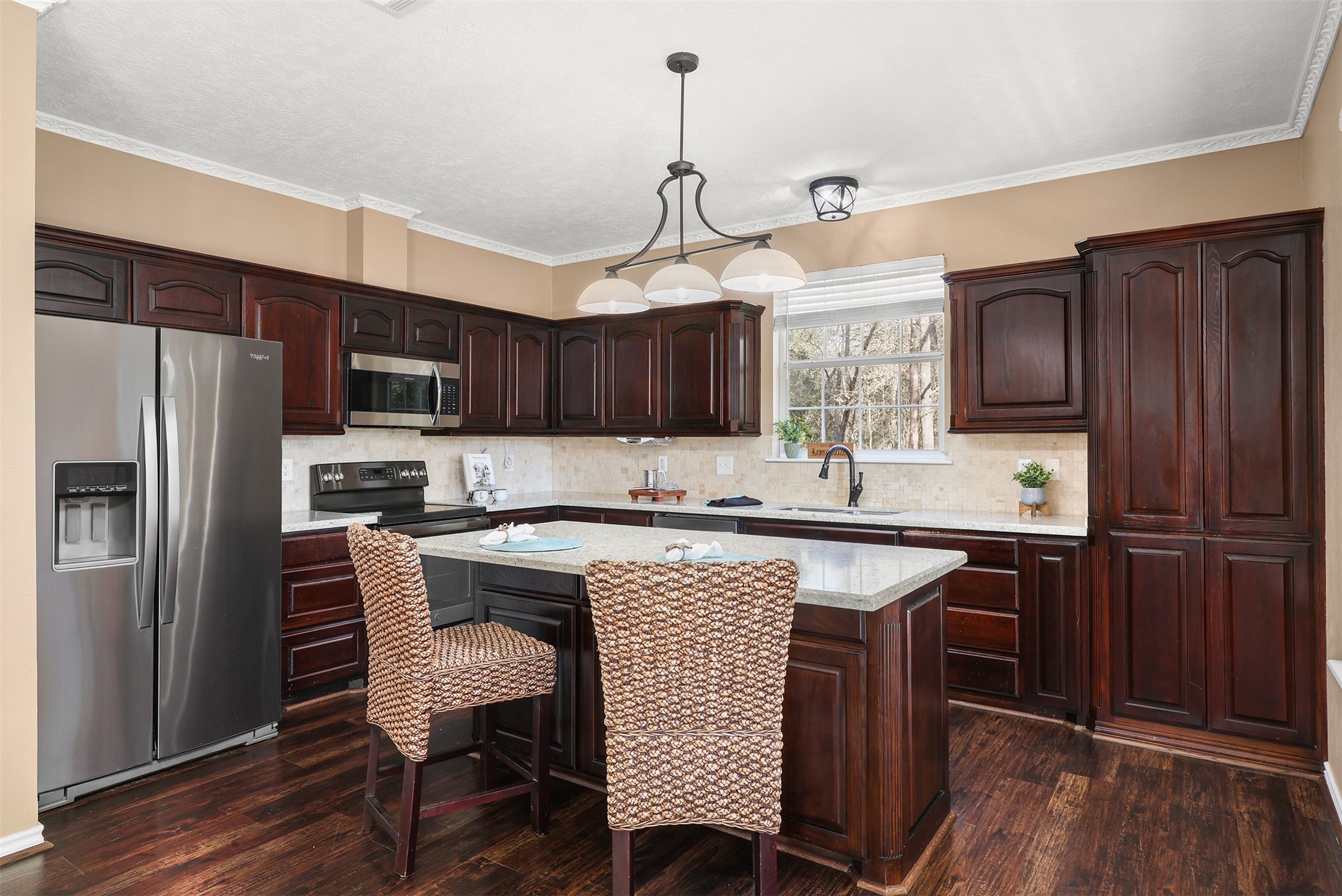 1635 Wallisville-Turtle Bayou Road Wallisville, TX 77597 - Photo 25 of 46 a kitchen with stainless steel appliances granite countertop a table chairs refrigerator and cabinets