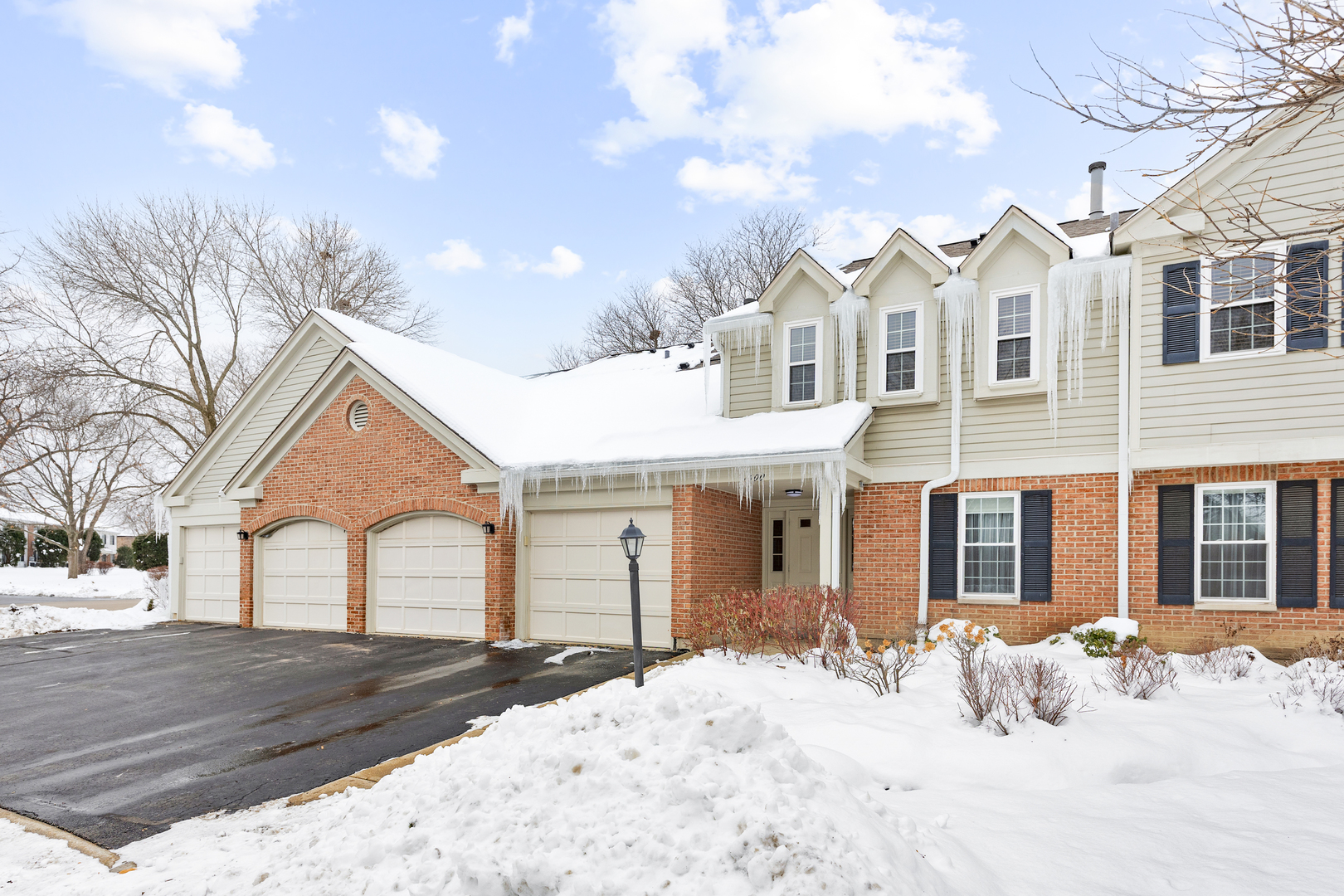 1600 Brittany Court, Unit C2 Wheeling, IL 60090 - Photo 2 of 27 a front view of a house with a yard covered in snow