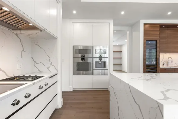 a kitchen with stainless steel appliances kitchen island granite countertop a table chairs sink and cabinets