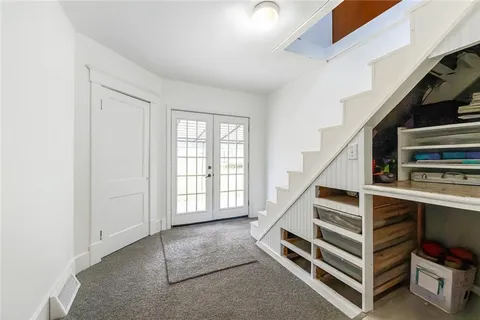 a view of an empty room with stairs and white walls