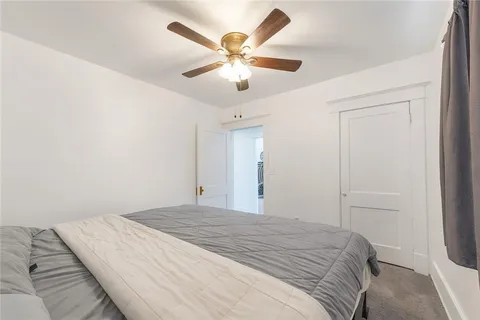 a bedroom with a large bed and a ceiling fan