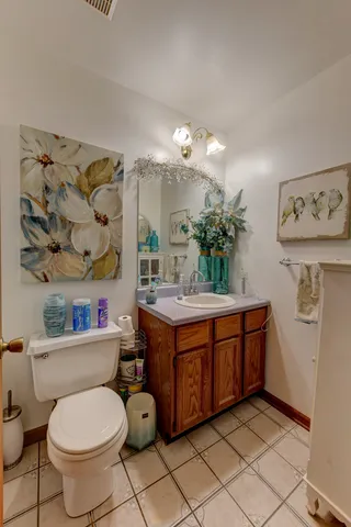 a bathroom with a granite countertop sink mirror vanity and toilet